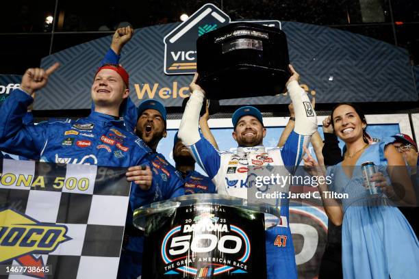 Ricky Stenhouse Jr., driver of the Kroger/Cottonelle Chevrolet, lifts the Harley J. Earl trophy in victory lane after winning the NASCAR Cup Series...