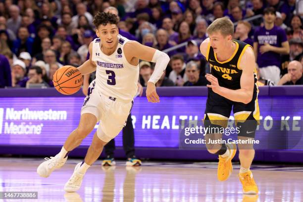 Ty Berry of the Northwestern Wildcats drives to the basket while defended by Josh Dix of the Iowa Hawkeyes during the first half at Welsh-Ryan Arena...