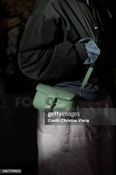 Guest wears green Coach bag outside Feben during London Fashion Week February 2023 on February 19, 2023 in London, England.