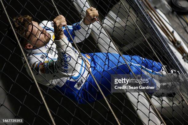 Ricky Stenhouse Jr., driver of the Kroger/Cottonelle Chevrolet, celebrates by climbing the fence after winning the NASCAR Cup Series 65th Annual...