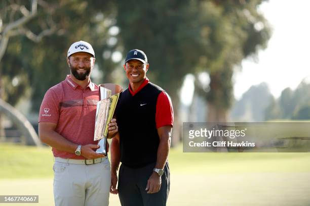The Genesis Invitational host, Tiger Woods of the United States, presents the trophy to Jon Rahm of Spain after putting in to win The Genesis...