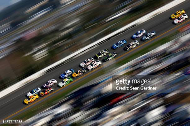 Joey Logano, driver of the Shell Pennzoil Ford, leads Martin Truex Jr., driver of the Bass Pro Shops Toyota, and Ross Chastain, driver of the...