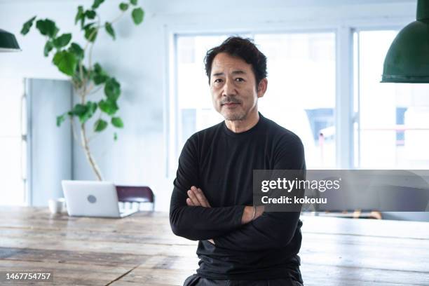 retrato de um homem olhando para uma câmera em um escritório moderno e elegante - mature man notebook - fotografias e filmes do acervo