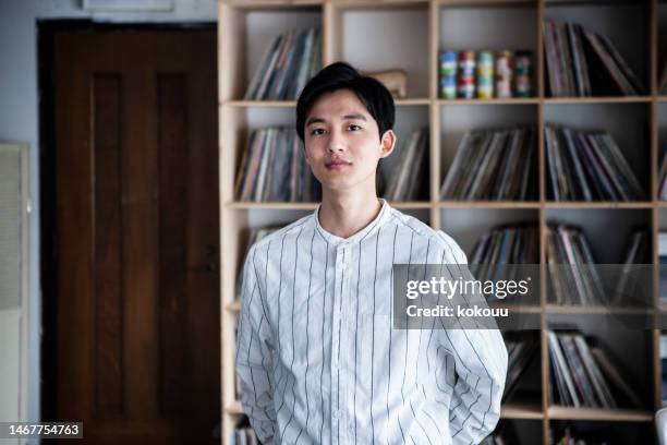 portrait of a man looking at a camera in a modern, stylish office - japanese ethnicity 個照片及圖片檔