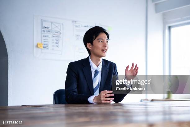 ein kandidat in einem büro erklärt sich dem interviewer - japaner stock-fotos und bilder