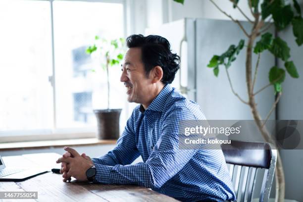 un entrevistador escuchando al candidato en la entrevista de trabajo en la oficina - japanese people fotografías e imágenes de stock