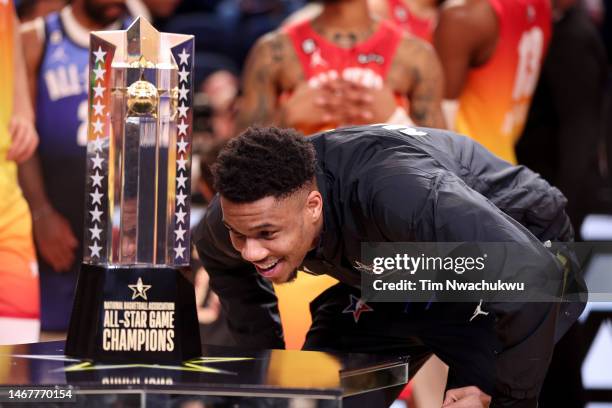 Giannis Antetokounmpo of the Milwaukee Bucks looks at the All-Star Game Champions trophy after winning the 2023 NBA All Star Game between Team...