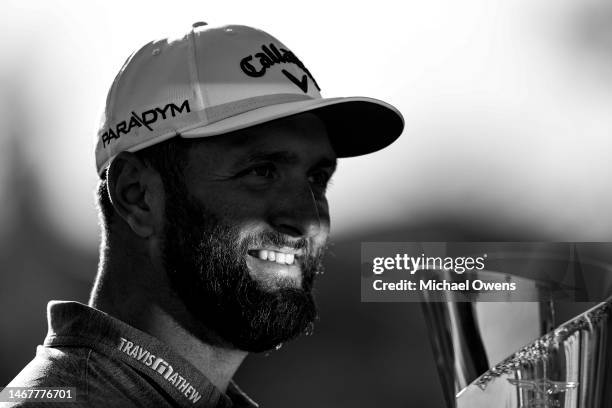 Jon Rahm of Spain celebrates with the trophy after putting in to win The Genesis Invitational at Riviera Country Club on the 18th green on February...