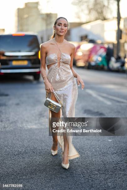 Tamara Kalinic wears a beige embroidered sequined halter-neck / shoulder-off / slit long dress a gold and diamonds Love bracelet from Cartier, a gold...