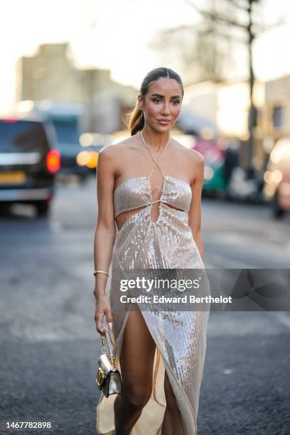 Tamara Kalinic wears a beige embroidered sequined halter-neck / shoulder-off / slit long dress a gold and diamonds Love bracelet from Cartier, a gold...