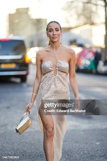 Tamara Kalinic wears a beige embroidered sequined halter-neck / shoulder-off / slit long dress a gold and diamonds Love bracelet from Cartier, a gold...