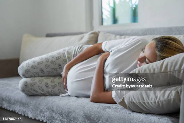 pregnant woman lying on sofa - morning sickness 個照片及圖片檔