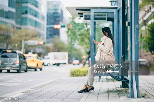 asian young business woman waiting for public bus at bus station ready to go to work - taiwan icon stock pictures, royalty-free photos & images