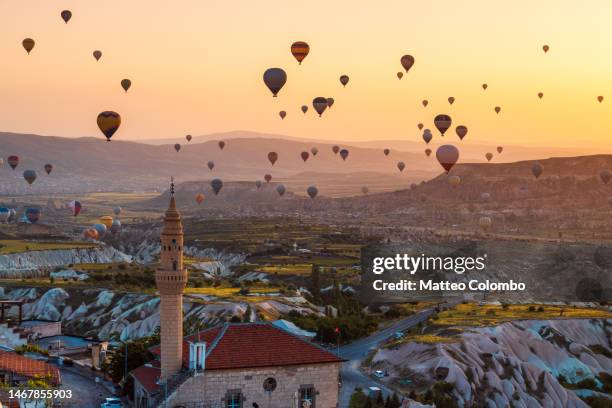 hot air balloons and minaret, cappadocia, turkey - göreme stock pictures, royalty-free photos & images