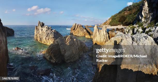 craggy rocks jutting out of the sea on the beach of lido la scogliera, tropea, vibo valentia, calabria, southern italy, italy - scogliera 個照片及圖片檔