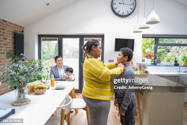 mother helping 10 year old son with school uniform necktie - helping people stock pictures, royalty-free photos & images