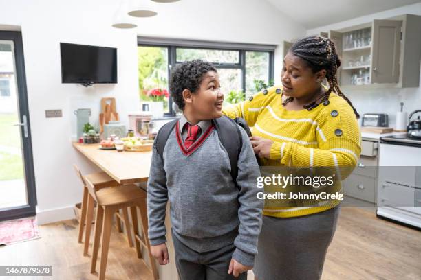 madre ayuda a su hijo de primaria a prepararse para la escuela - day 11 fotografías e imágenes de stock