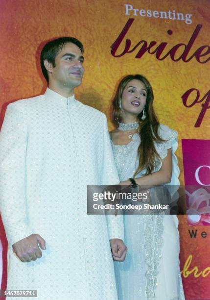Bollywood actors Arbaaz Khan with wife Malaika Arora walk the ramp during a fashion show in New Delhi.