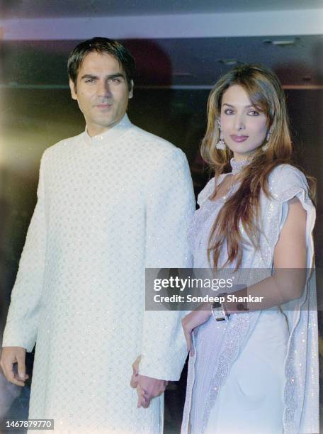 Bollywood actors Arbaaz Khan with wife Malaika Arora walk the ramp during a fashion show in New Delhi.