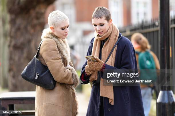 Model wears a beige suede with fur large borders long coat, blue denim large pants, a black GG monogram print pattern shoulder bag from Gucci, a...