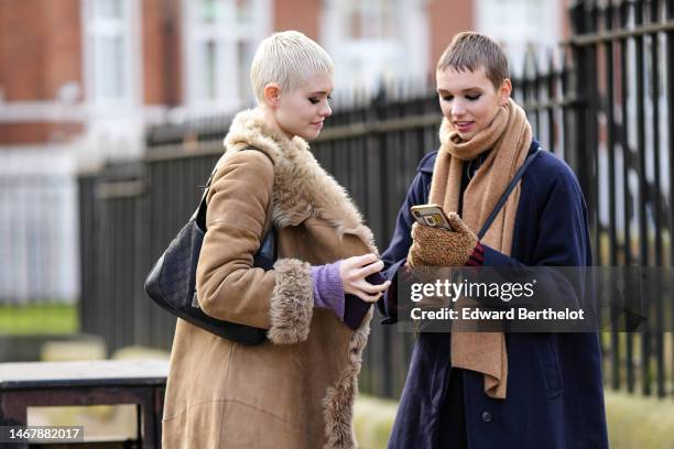 Model wears a beige suede with fur large borders long coat, blue denim large pants, a black GG monogram print pattern shoulder bag from Gucci, a...