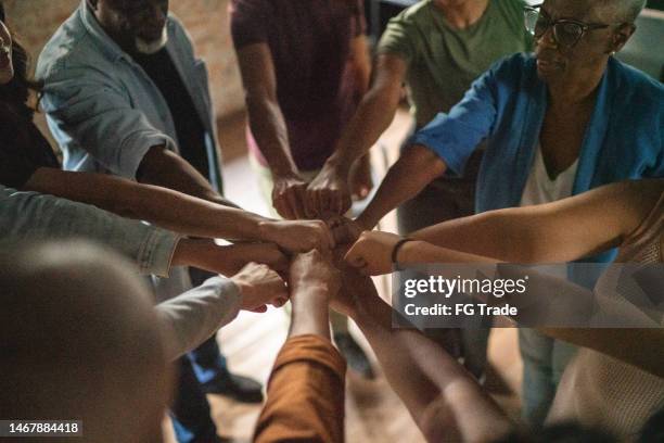 equipo haciendo golpe de puño - hands clasped fotografías e imágenes de stock