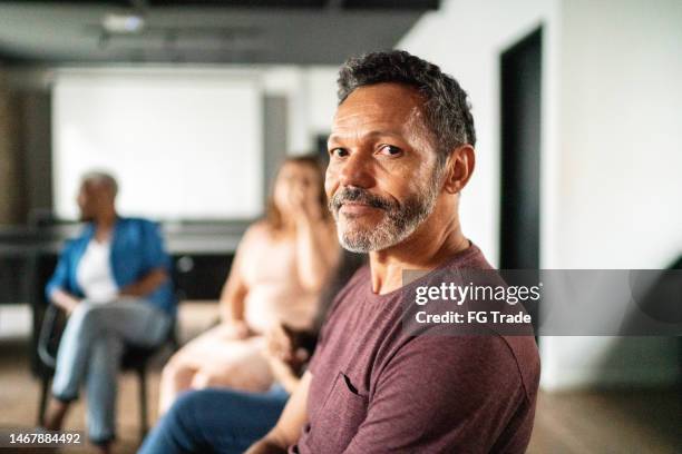 portrait of a mature man at group therapy - employee welfare stockfoto's en -beelden