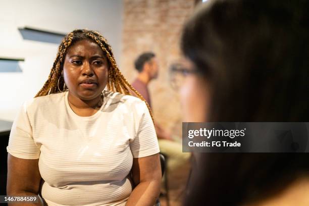 duas mulheres conversando em sessão de aconselhamento - preconceito - fotografias e filmes do acervo