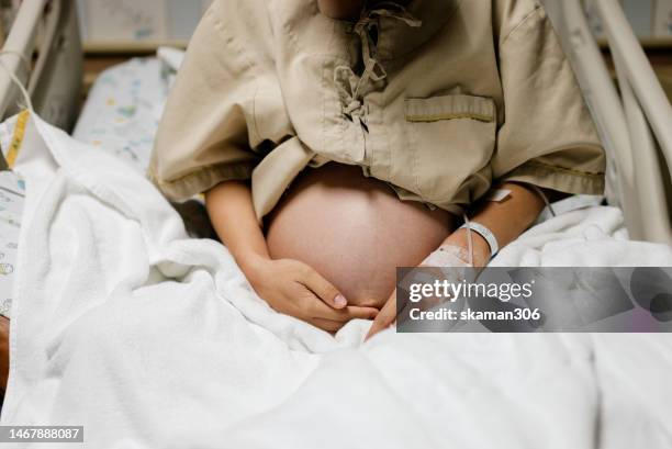 close up belly of asian mother pregnant 40 weeks ready to give birth - family photo in the delivery room stock pictures, royalty-free photos & images