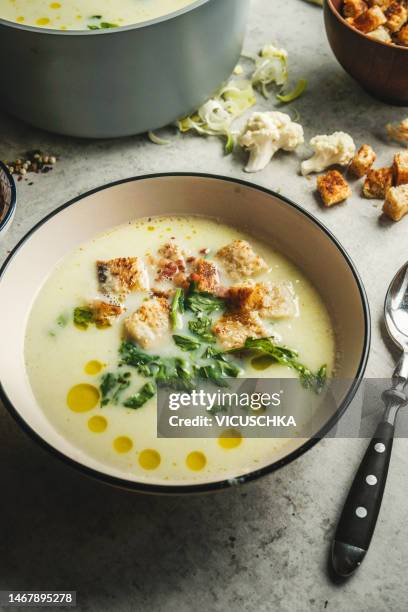 bowl with delicious creamy cauliflower soup with croutons, fresh herbs and oil drops - cream soup stock pictures, royalty-free photos & images