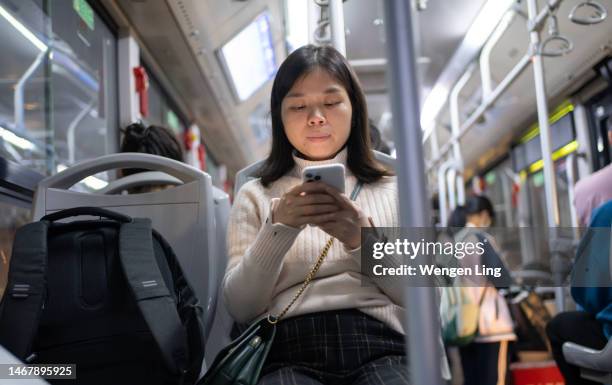 asian woman using mobile phone on bus - public service stock pictures, royalty-free photos & images