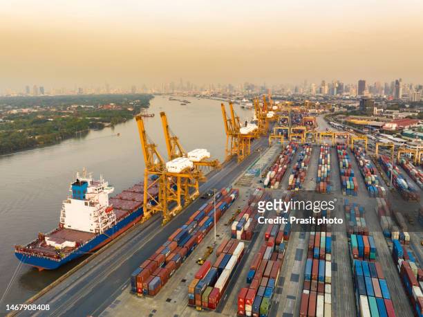 aerial view of containers lining the wharf annd there is a container ship waiting to load and unload the goods at the crane on the chao phraya river in bangkok, thailand - hub stock pictures, royalty-free photos & images