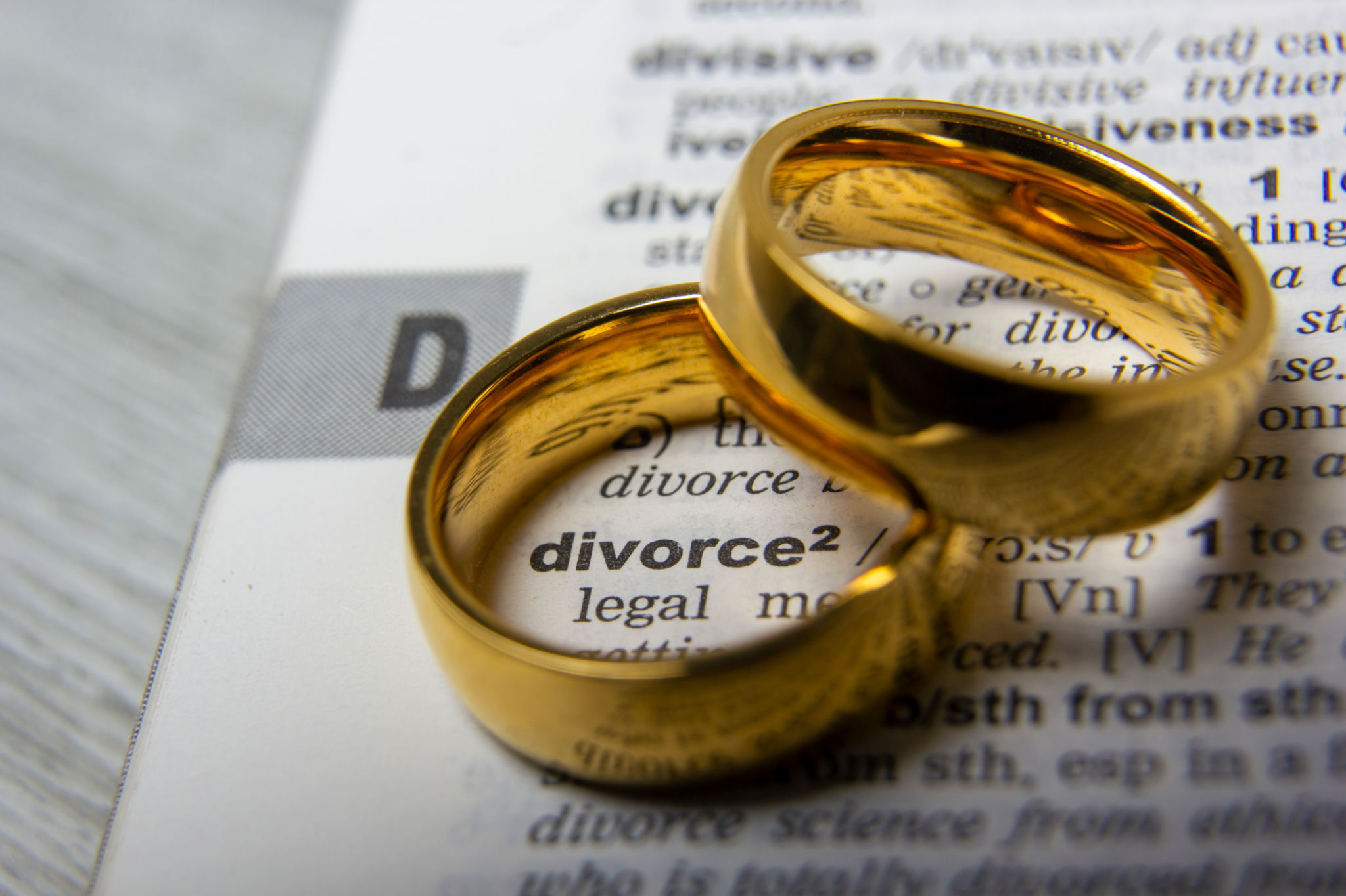 Divorce concept. Law and Justice background. Judge gavel on with two golden wedding rings Divorce concept. Law and Justice background. Judge gavel on with two golden wedding rings