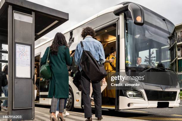 passengers boarding in bus - long coat stock pictures, royalty-free photos & images