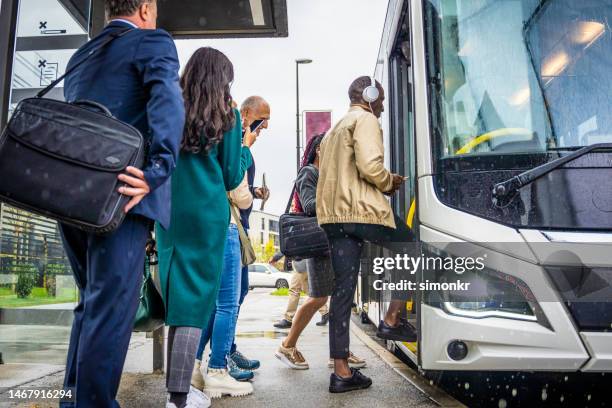 passengers getting in bus - bushalte stockfoto's en -beelden