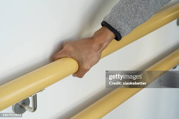 man's hand holding a safety rail on the wall - ageing population stock pictures, royalty-free photos & images