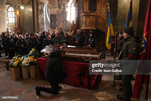 Mourner kneels at the coffin of Ruslan Zastavny a volunteer in Ukraine's Territorial Defence Forces, during his funeral at the Church of the Most...