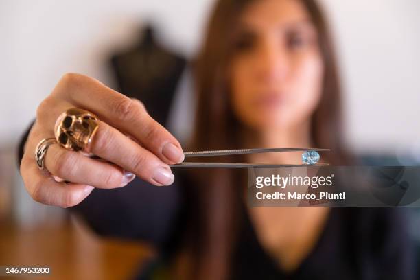 woman jeweller looking gemstone - diamond jeweller stock pictures, royalty-free photos & images