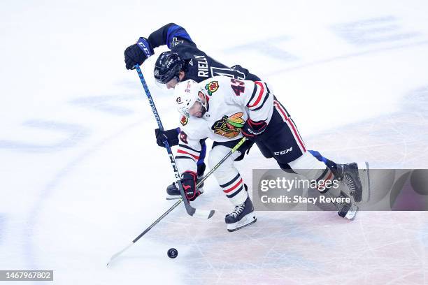Morgan Rielly of the Toronto Maple Leafs and Colin Blackwell of the Chicago Blackhawks works for a loose puck during a game at United Center on...