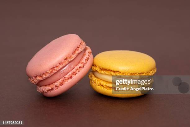 lemon and strawberry macarons on brown background - macaroon photos et images de collection