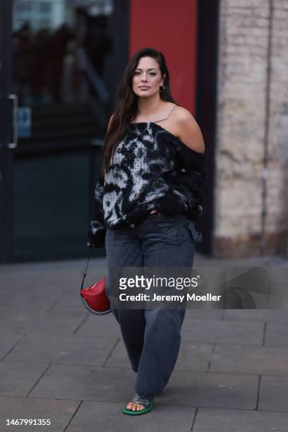 Ashley Graham seen wearing a black and white patterned shirt, dark jeans, a red bag and green and silver glitter heels before the JW Anderson show...