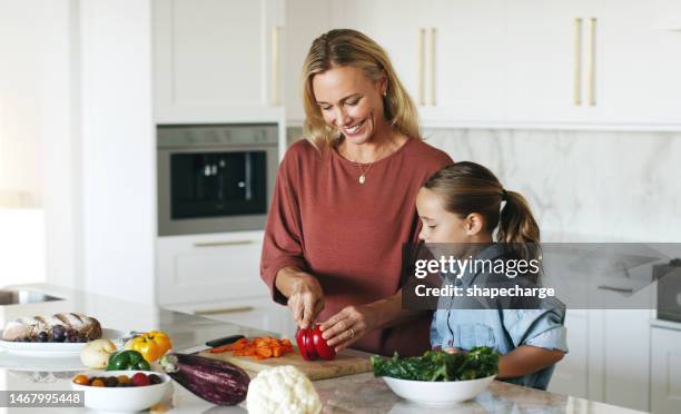 la maison, la cuisine et la mère avec l’enfant dans la cuisine ensemble faire une salade saine pour le dîner ou le déjeuner. santé, alimentation et maman apprenant à la fille à cuisiner, éducation alimentaire avec sourire pour femme et enfant dans - family smile photos et images de collection