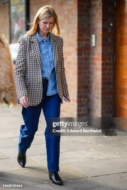 Guest wears a pale blue denim shirt, a brown / beige / black checkered print pattern blazer jacket, navy blue denim large pants, black shiny leather...