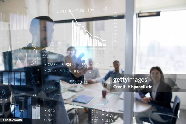 man in a business meeting using an interactive screen while giving a presentation - geld verdienen stockfoto's en -beelden