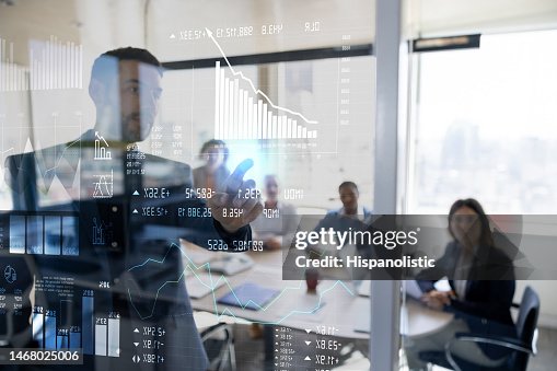 Man in a business meeting using an interactive screen while giving a presentation Man in a business meeting using an interactive screen while giving a presentation