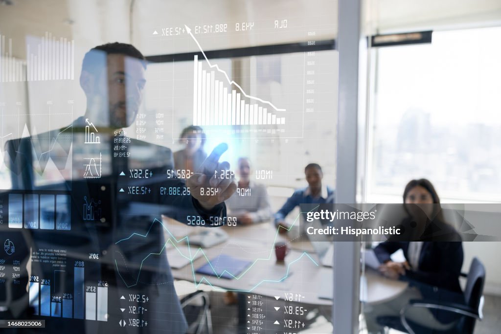Man in a business meeting using an interactive screen while giving a presentation
