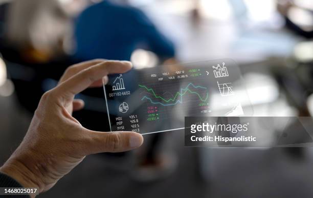 business man looking at the stock market behavior on an interactive screen - smartphone hologram stock pictures, royalty-free photos & images