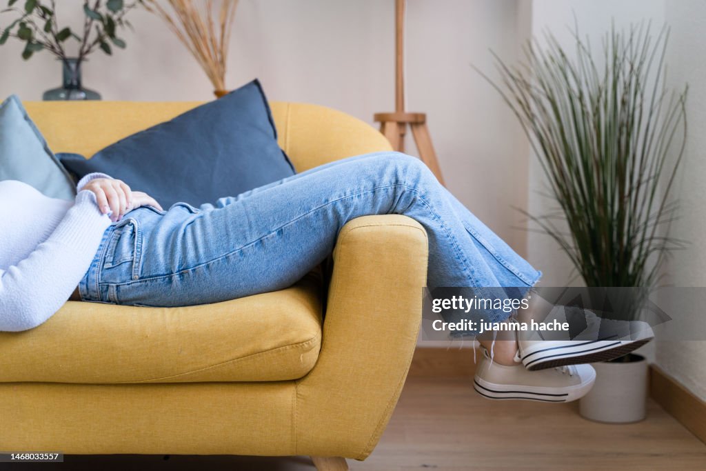 Crop woman sitting on sofa