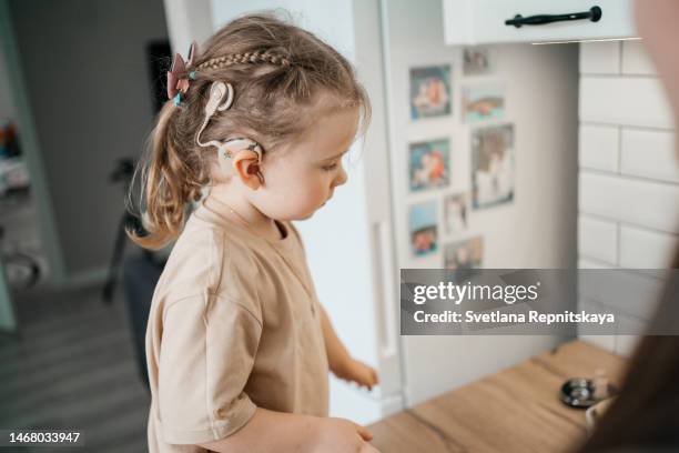 child with cochlear implant at home - cochlea implant stock pictures, royalty-free photos & images