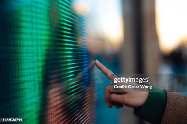 close-up of female hand touching futuristic digital screen - finger touchscreen stock-fotos und bilder